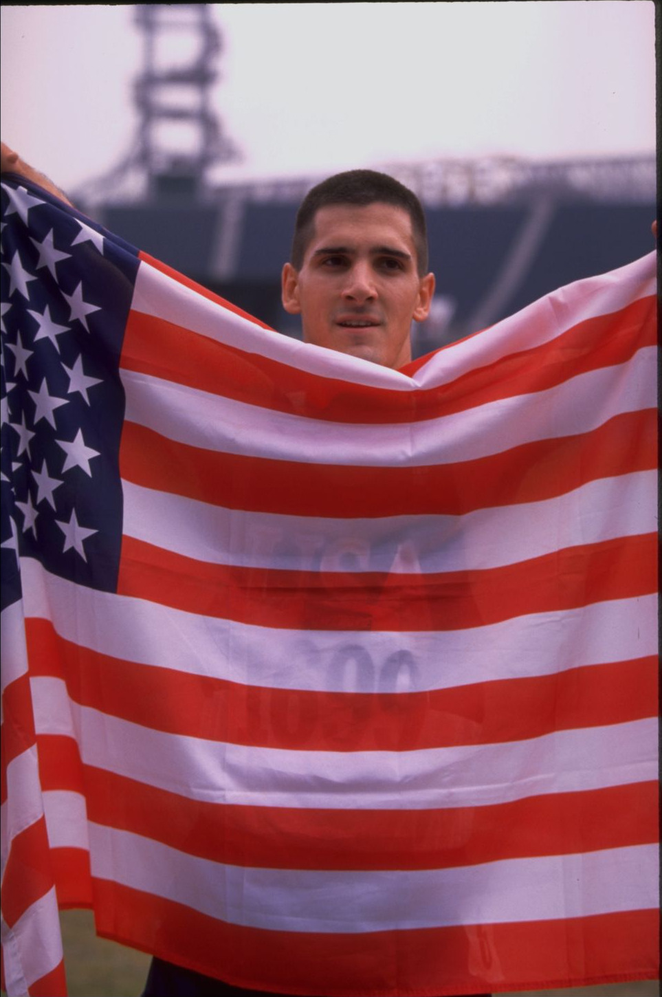 Tony Volpentest looking over a US flag he holds spread wide