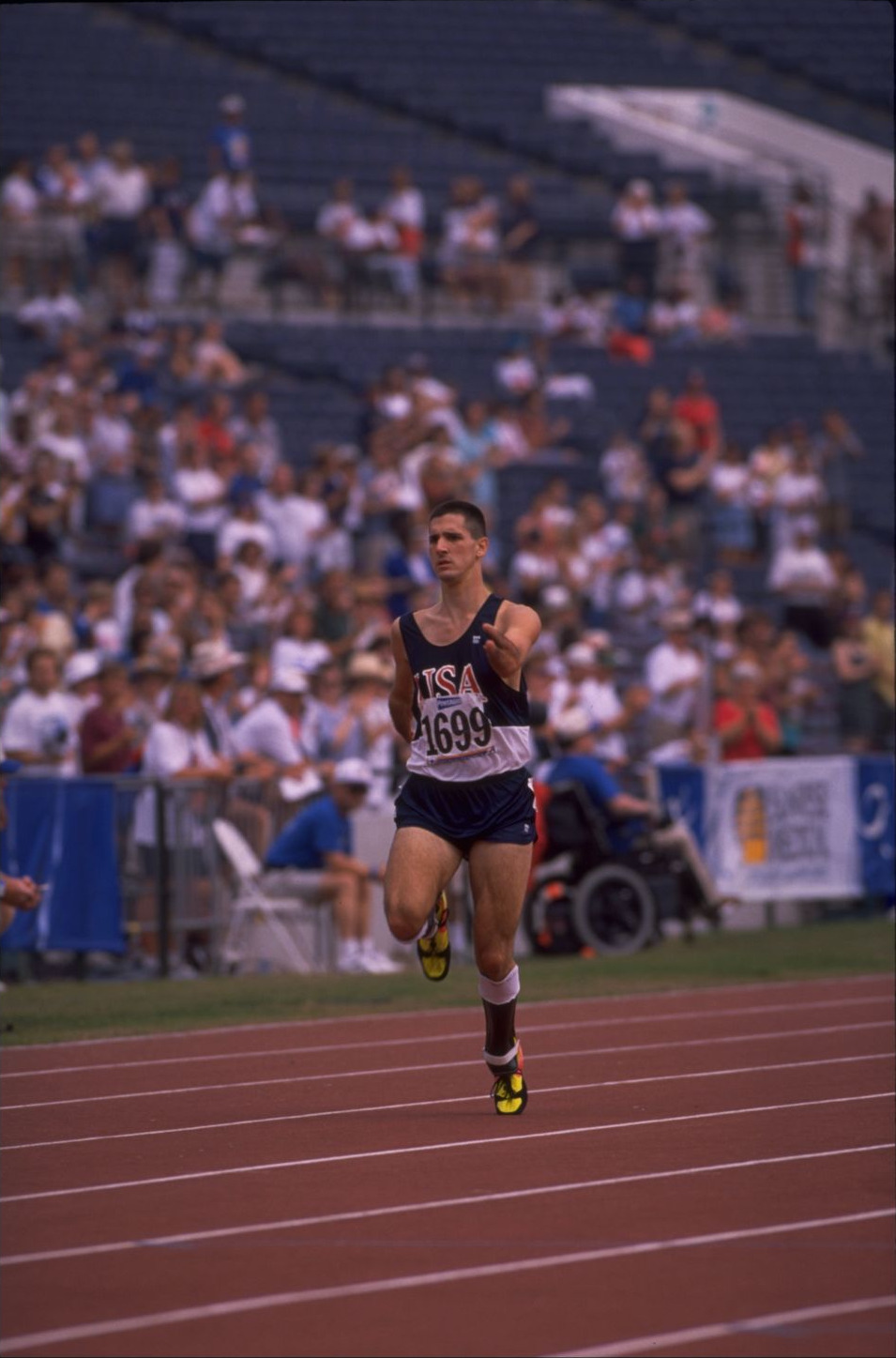 Tony Volpentest alone in frame mid-race, crowd and empty lanes behind