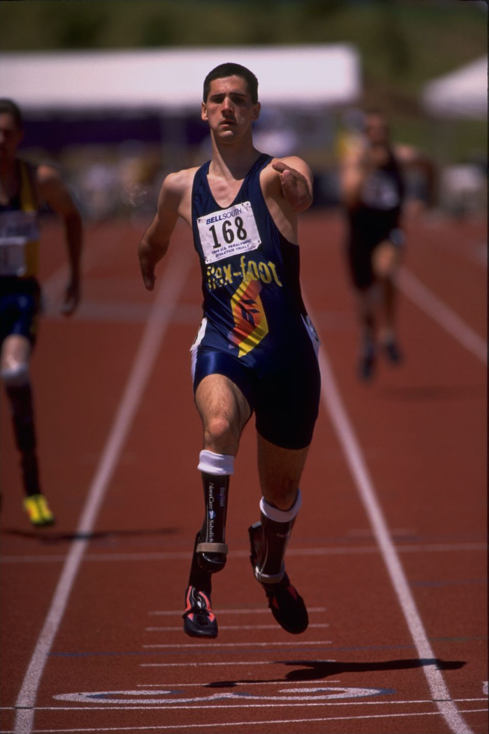 Tony Volpentest head-on at full speed, bib 168, both blades off the ground
