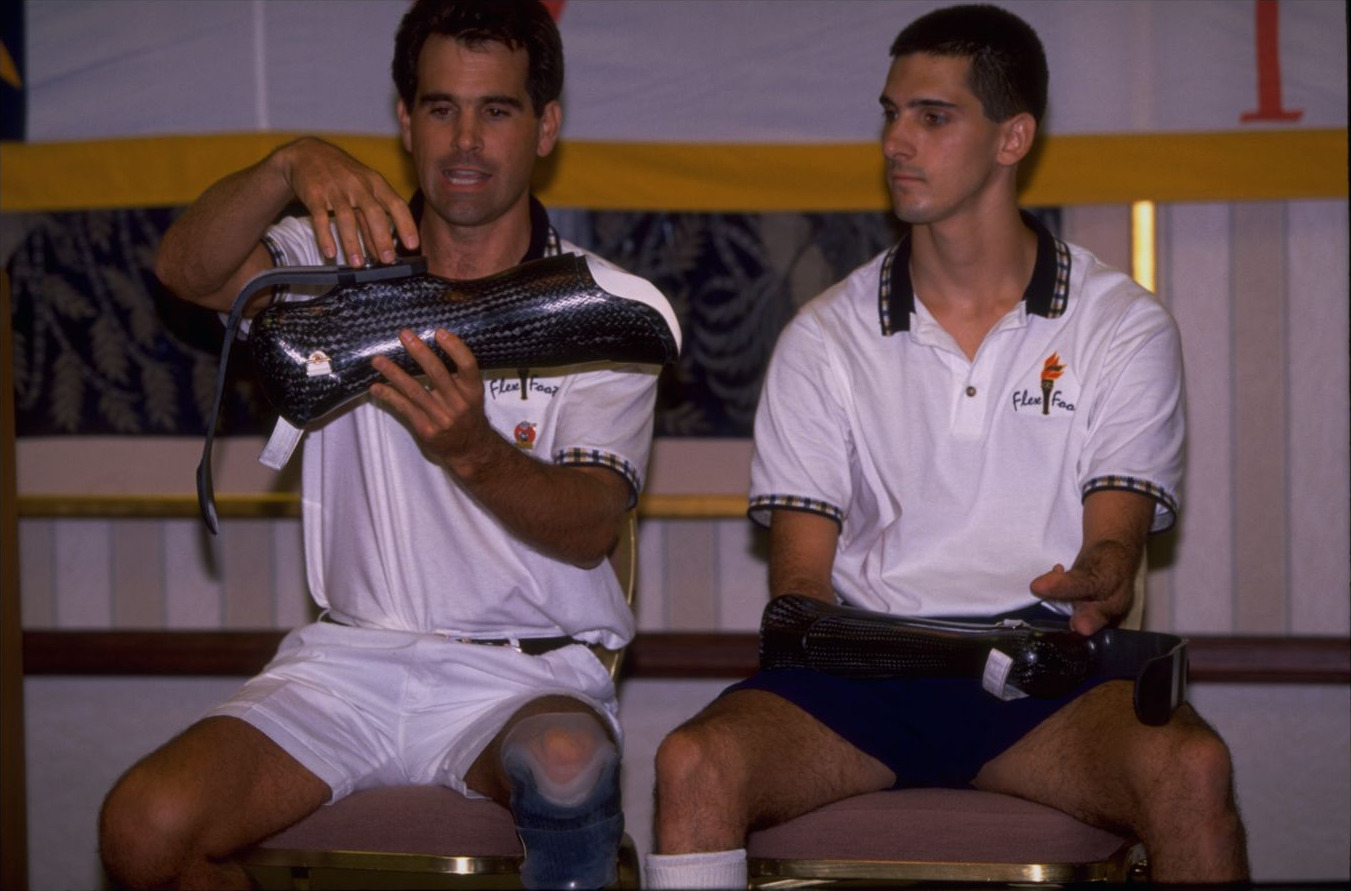 Tony Volpentest seated beside Van Phillips, inventor of the Flex-Foot, who holds a carbon-fiber running foot