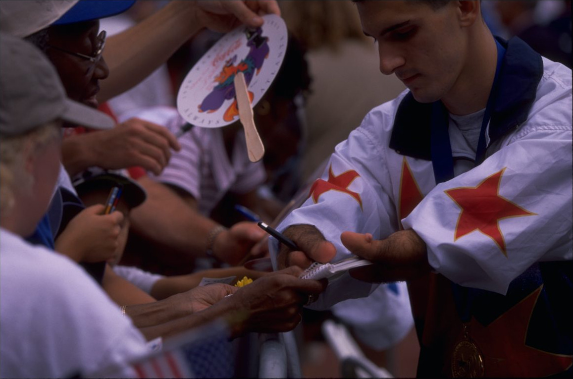 Tony Volpentest signing autographs for fans, gold medal around his neck